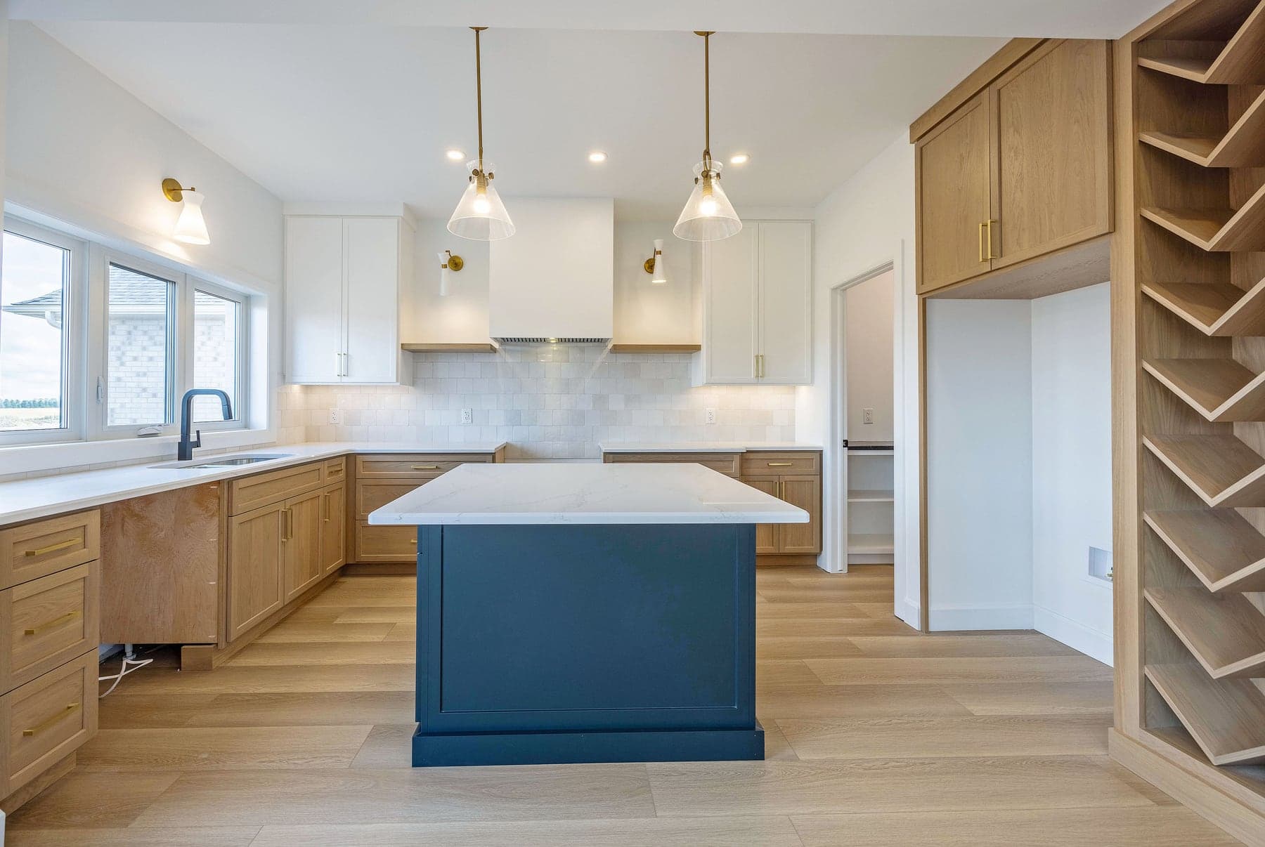 White oak kitchen with a navy island in a completed SBR home